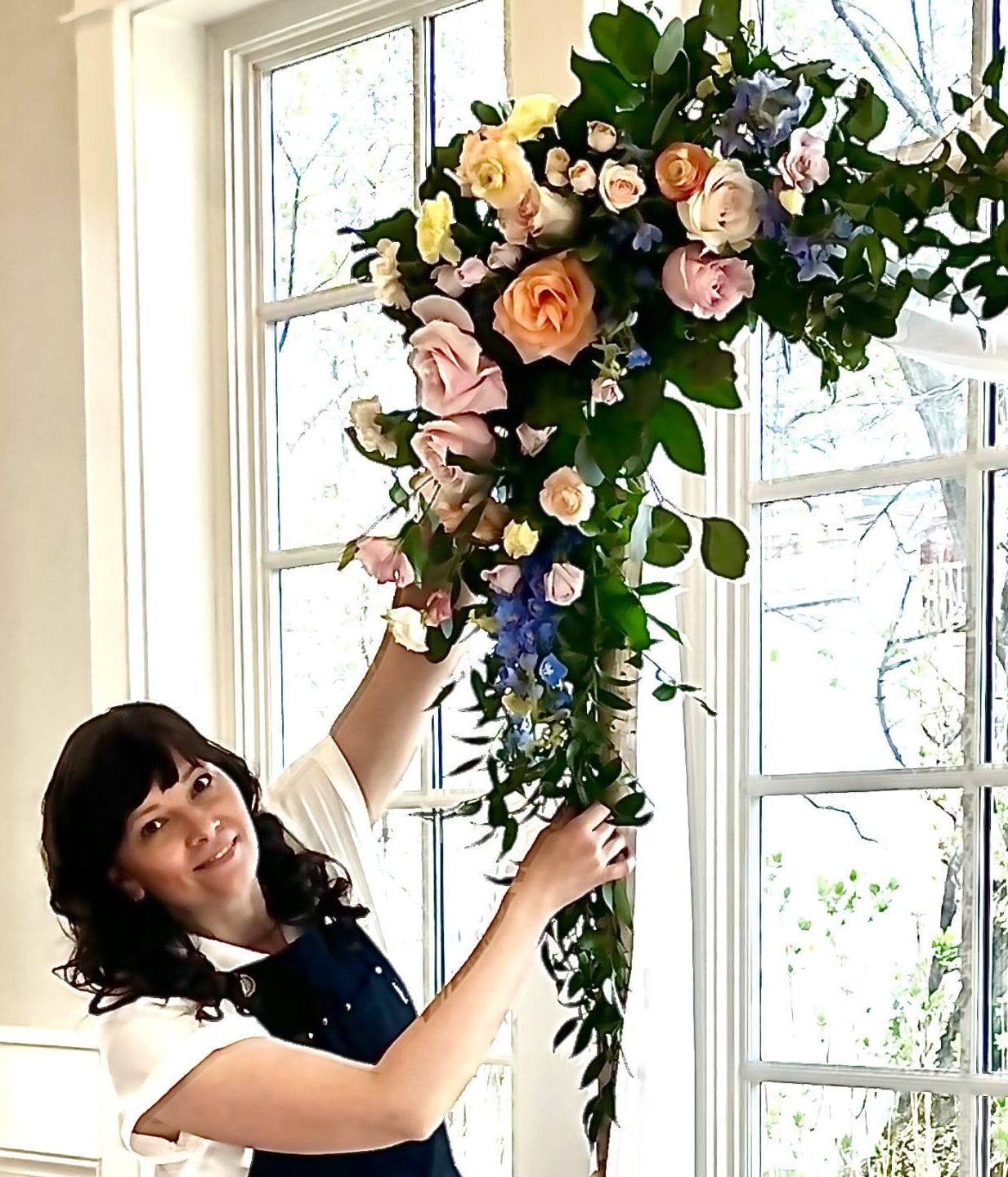 Florist-adding-flowers-to-wedding-arch