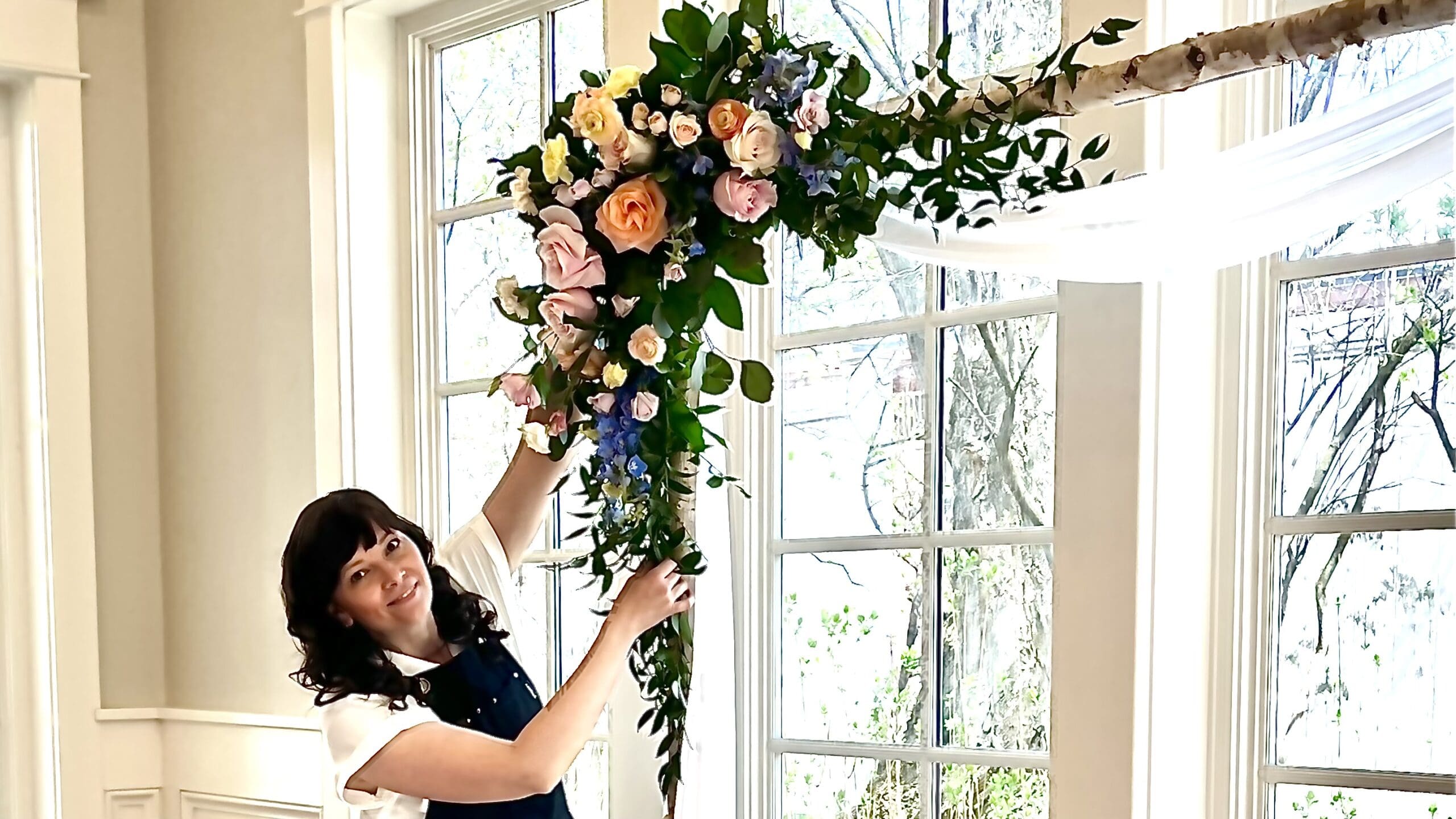 Florist-adding-flowers-to-wedding-arch