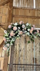 Blush and white flowers on the wedding arch